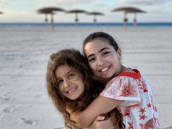 Portrait of two young girls hugging at beach. friendship sisters