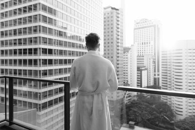 Rear view of man looking at city buildings