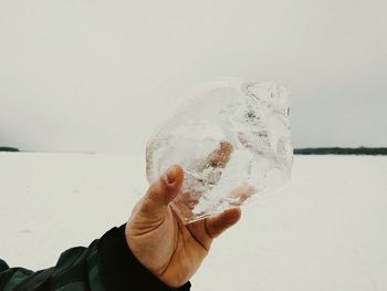 Close-up of hand against water