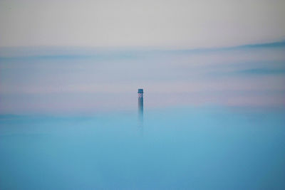 Lighthouse by sea against sky