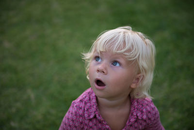 Close-up of cute shocked girl looking away