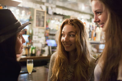 Happy young friends enjoying drinks at a bar