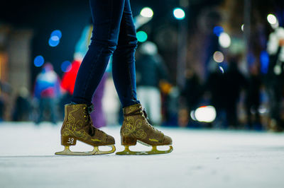 Low section of person skiing on ice rink