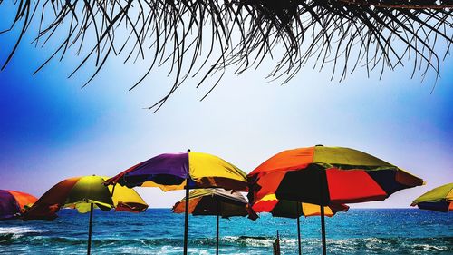 Multi colored umbrellas on beach against sky