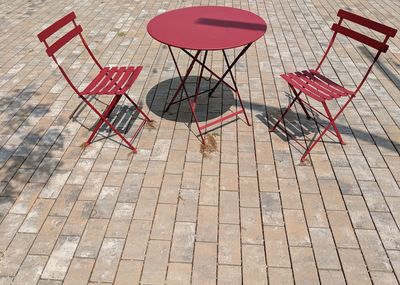 High angle view of empty chairs on footpath