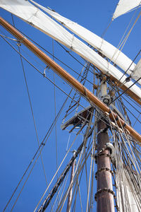 Low view of sailboat sailing on sea against sky in iceland, husavik, full power ahead, mast