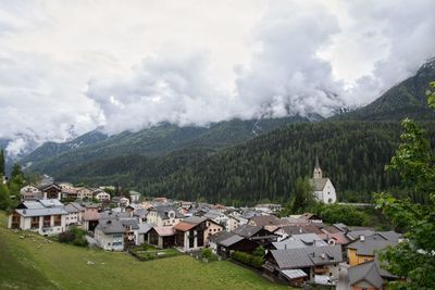 Houses on green landscape against sky