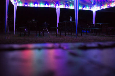 Empty chairs and tables at night