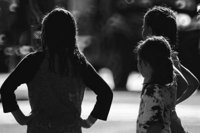 Rear view of women standing outdoors