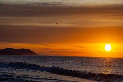 Scenic view of sea against orange sky