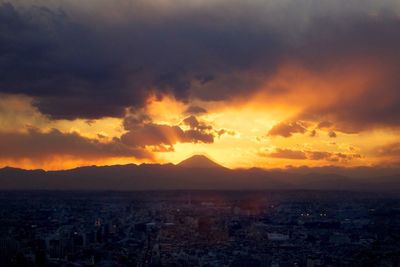 Scenic view of mountains against cloudy sky at sunset