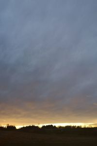 Scenic view of silhouette field against sky at sunset
