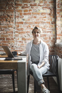 Portrait of female hacker sitting on chair in office