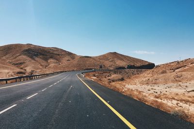 Road by mountain against clear sky