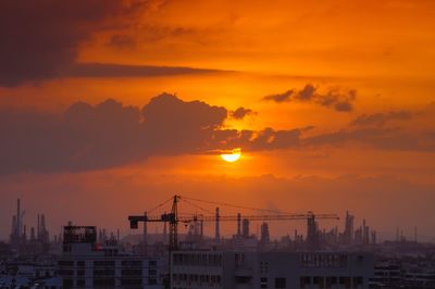 View of factory against orange sky