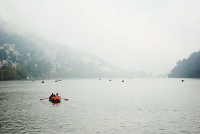 People on boat against sky