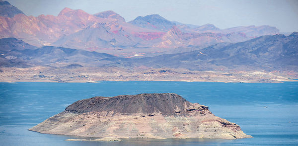Scenic view of sea and mountains against sky
