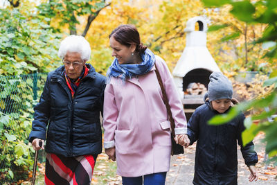 Senior woman walking with daughter and great grandson in park