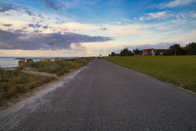 Road leading towards city during sunset