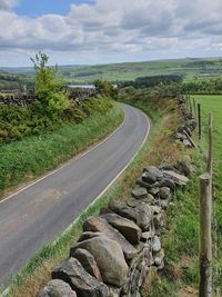 Road amidst field against sky