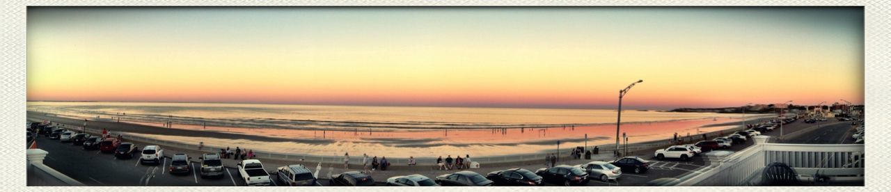 transfer print, sunset, sea, horizon over water, beach, large group of people, auto post production filter, clear sky, water, orange color, shore, sky, scenics, sand, transportation, sun, high angle view, nature, beauty in nature, incidental people