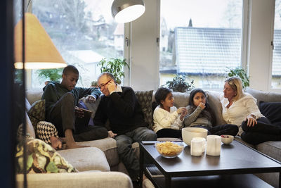 Multi-generation family sitting on sofa at home