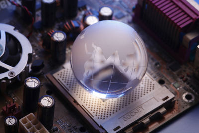 High angle view of glass globe on computer equipment