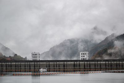 Bridge over river against sky during winter