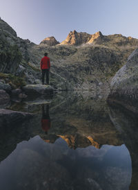 A young man stands on a rock during sunrise at sierra de gredos, spain