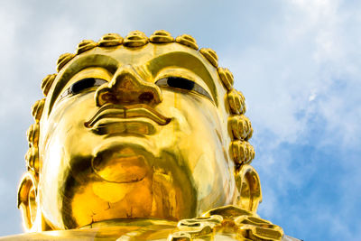 Close up of head larg golden buddha on blue sky background ,thailand