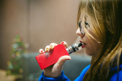 Close-up of young woman smoking electronic cigarette