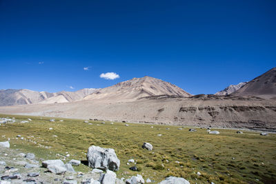 Scenic view of mountains against blue sky