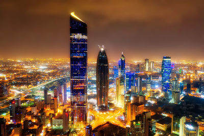 Illuminated buildings in city against sky at night