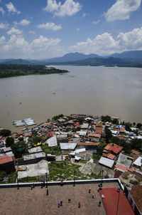 High angle view of townscape by sea against sky