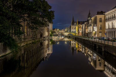 Scenic view of illuminated old town and canal at night