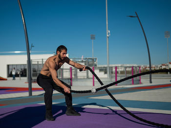 Side view of young woman exercising at gym