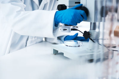 Midsection of scientist examining chemical in laboratory