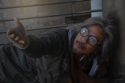 Senior man giving hand while lying down outdoors