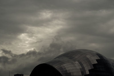 Low angle view of modern building against cloudy sky