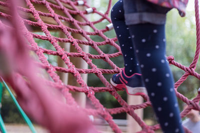 Low section of child on rope in park