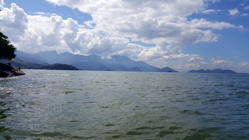 Scenic view of sea and mountains against sky