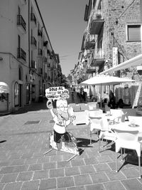 People on street amidst buildings in city