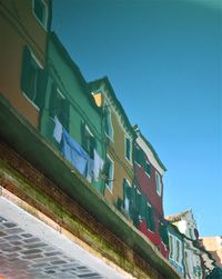 Low angle view of buildings against clear blue sky