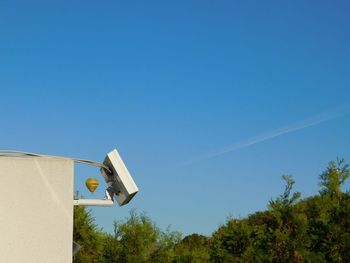 Low angle view of telephone pole against clear blue sky