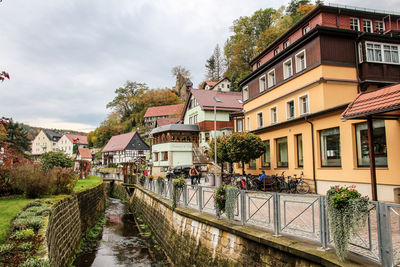 Canal amidst houses and buildings against sky