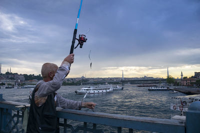 Man on boat in river against sky