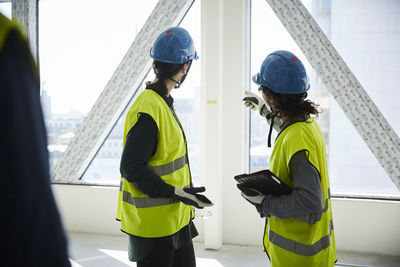 Side view of female engineers discussing at construction site