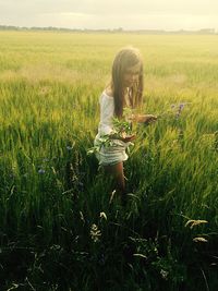 Rear view of woman standing on grassy field