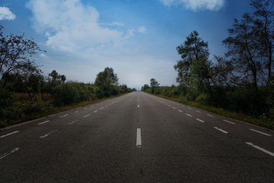 Road amidst trees against sky