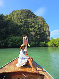 Full length of woman sitting on boat in sea